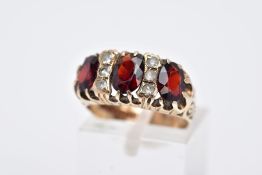 A LATE 20TH CENTURY 9CT GOLD GARNET RING, designed with three oval cut garnets, interspaced with