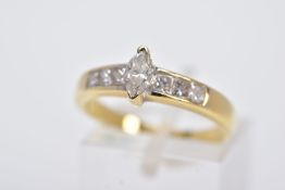 A YELLOW METAL DIAMOND RING, designed with a central raised, marquise cut diamond, flanked with