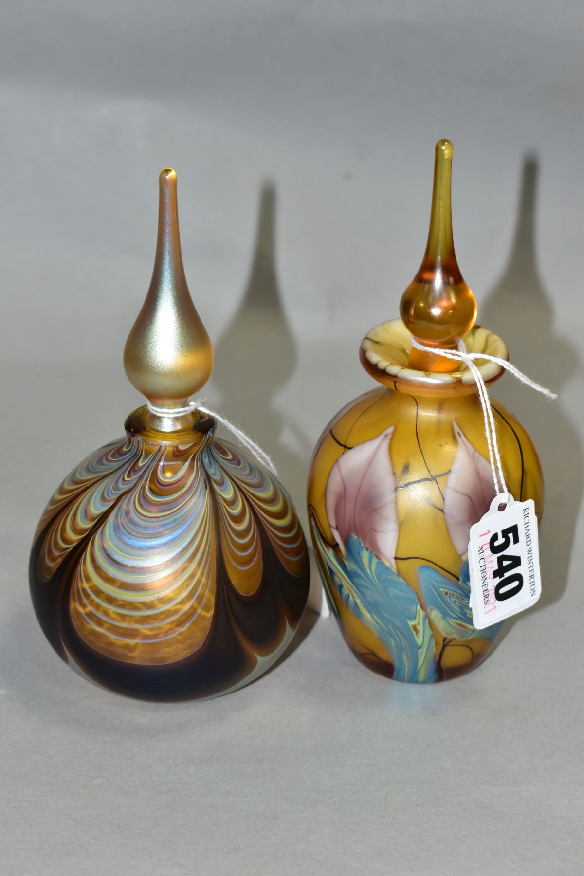 TWO IRIDESCENT PERFUME BOTTLES AND STOPPERS, one of baluster form, height 16cm, the other of bulbous