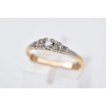 A YELLOW METAL DIAMOND RING, tiered design centring on a round brilliant cut diamond, flanked with