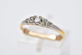 A YELLOW METAL DIAMOND RING, tiered design centring on a round brilliant cut diamond, flanked with