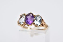 A 9CT GOLD THREE STONE RING, centring on an oval cut amethyst, flanked with two oval cut