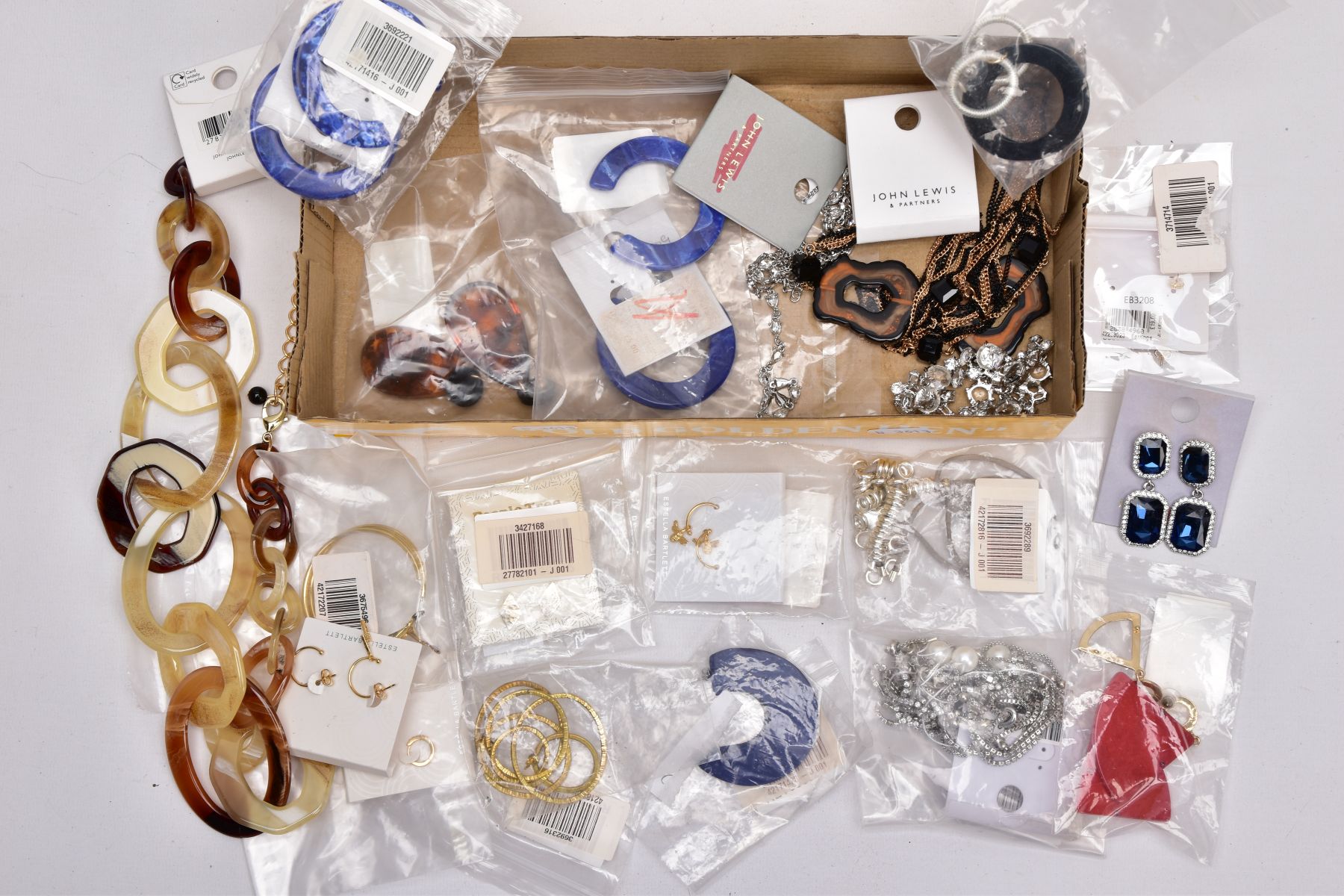 A TRAY OF COSTUME JEWELLERY, some pieces with tags and packaging, to include a large resin hoop