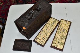 A LATE 19TH/EARLY 20TH CENTURY MAH JONG SET, the bone and bamboo playing pieces housed in a relief