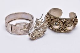 A WHITE METAL BANGLE, CUFF BANGLE AND A RING, the hinged bangle of a belt and buckle design, foliate