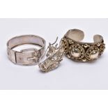 A WHITE METAL BANGLE, CUFF BANGLE AND A RING, the hinged bangle of a belt and buckle design, foliate