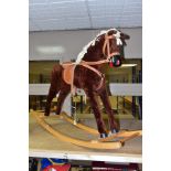A MODERN WOODEN ROCKING HORSE, covered in brown plush with string tail and mane, painted mouth, nose
