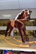 A MODERN WOODEN ROCKING HORSE, covered in brown plush with string tail and mane, painted mouth, nose