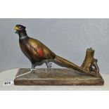 AN EARLY 20TH CENTURY PAINTED SPELTER TABLE LIGHTER IN THE FORM OF A COCK PHEASANT STANDING BY A