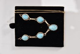 A YELLOW METAL LARIMAR NECKLET, fitted with five larimar cabochons, interspaced with elongated