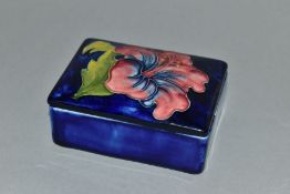 A MOORCROFT POTTERY RECTANGULAR TRINKET BOX AND COVER WITH PINK HIBISCUS, blue ground, impressed and