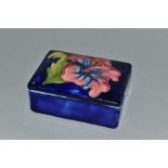 A MOORCROFT POTTERY RECTANGULAR TRINKET BOX AND COVER WITH PINK HIBISCUS, blue ground, impressed and