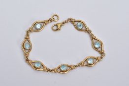 A YELLOW METAL BLUE TOPAZ LINE BRACELET, designed with seven lozenge shaped openwork sections,
