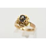 A YELLOW METAL SAPPHIRE CABOCHON RING, designed with a raised claw set sapphire cabochon, upon an