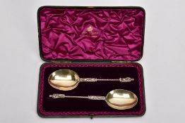 A CASED TWO PIECE LATE VICTORIAN SILVER GILT SPOON SET, brown case opens to reveal a purple velvet