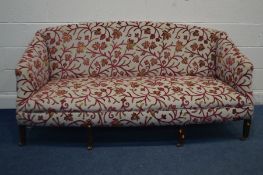 A GEORGIAN SOFA, on seven mahogany legs and brass casters, reupholstered red foliate decoration with