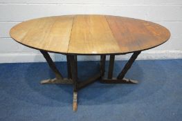 IN THE MANNER OF ARTHUR ROMNEY GREEN (c1872-1945) AN OAK ARTS AND CRAFTS GATE LEG TABLE, oval top,