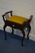 AN EDWARDIAN MAHOGANY PIANO STOOL, with mustard upholstery, shaped arm rests on cabriole legs,