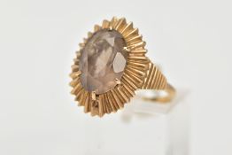 A 9CT GOLD SMOKY QUARTZ RING, of an oval form, set with a claw set oval cut smoky quartz, within a