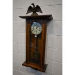 A LATE VICTORIAN WALNUT VIENNA EIGHT DAY WALL CLOCK, with papier Mache eagle pediment, enamel dial