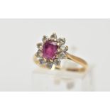 A 9CT GOLD RUBY AND DIAMOND CLUSTER RING, centring on an oval cut ruby, within a claw set, round