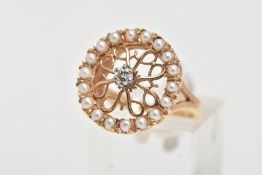 A 14CT GOLD DIAMOND AND SEED PEARL RING, of a circular form, centring on a raised and claw set,