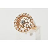 A 14CT GOLD DIAMOND AND SEED PEARL RING, of a circular form, centring on a raised and claw set,