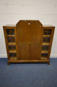 AN ART DECO OAK SIDE BY SIDE BUREAU/BOOKCASE, a central fall front door enclosing a fitted
