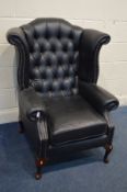 A BLACK FAUX LEATHER BUTTONED WINGBACK ARMCHAIR (this chair does not comply with the Furniture and