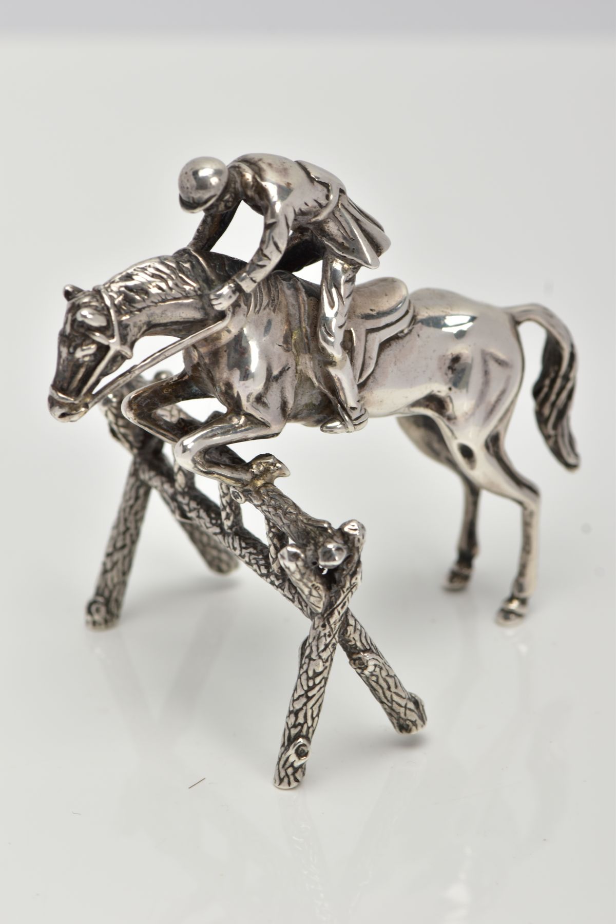 A SILVER SMALL HORSE AND JOCKEY ORNAMENT, measuring approximately 50mm in length x 70mm in height,