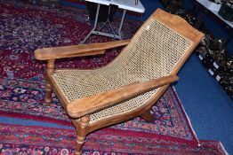 AN EARLY 20TH CENTURY PLANTATION CHAIR, with leg extenders, with rattan seat, width 66cm x depth