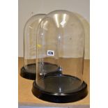 A PAIR OF MODERN DISPLAY GLASS DOMES on black glazed ceramic bases, height excluding bases