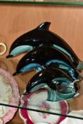 A GRADUATED SET OF THREE POOLE POTTERY DOLPHINS, black and turquoise blue glazes, printed marks,