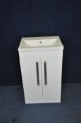 AN AMS PLUMBING WC SINK UNIT with a shallow ceramic sink standing on a white hi gloss two door