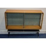 A TEAK TUNIDGE OF LONDON CHINA CABINET with curved edges, double sliding door enclosing three