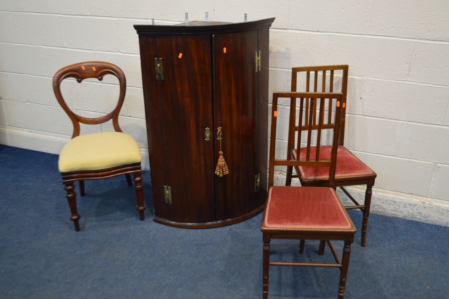 A GEORGIAN MAHOGANY BARREL HANGING CORNER CUPBOARD, three small drawers to interior and three