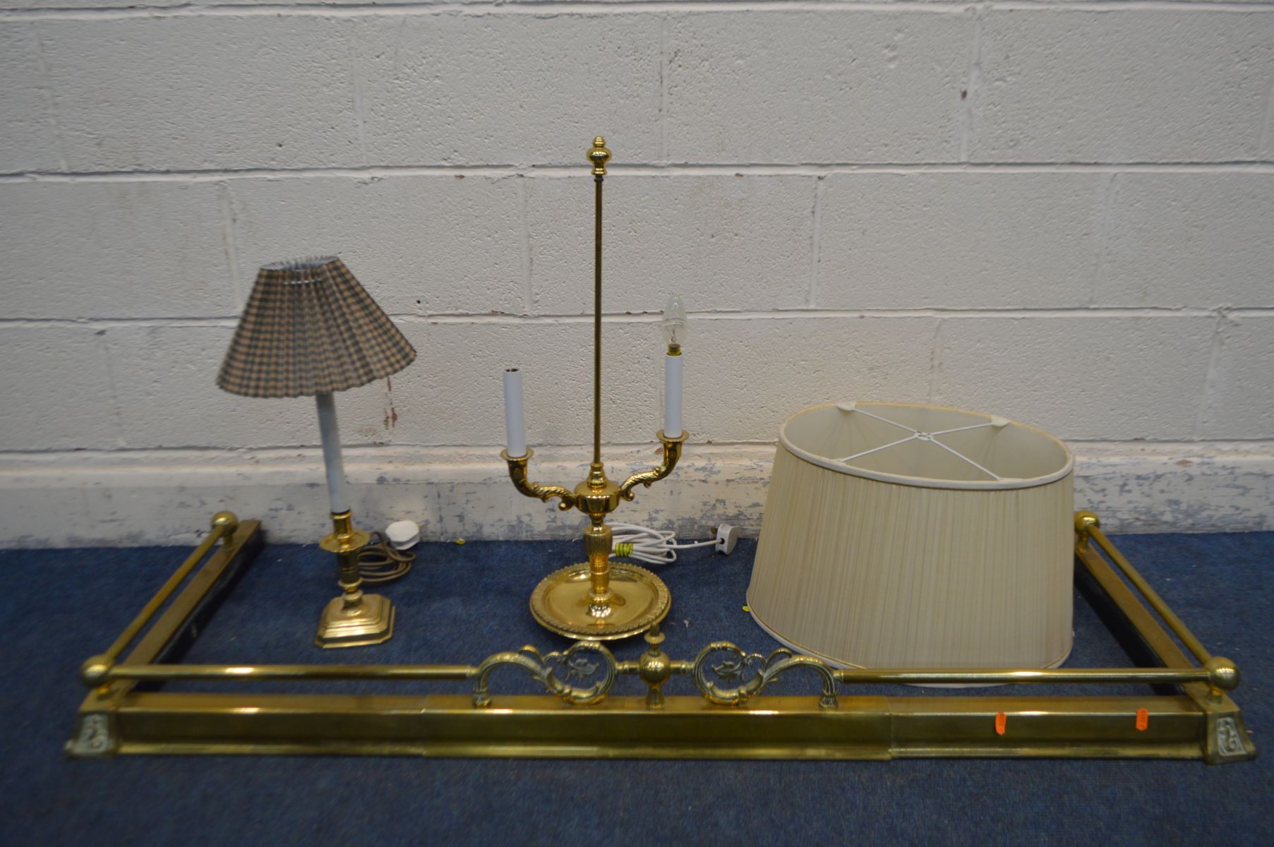 A BRASS EXTENDING FENDER, along with a brass twin branch table lamp with oval shade, and a another
