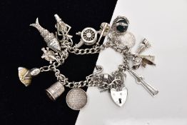 A SILVER CHARM BRACELET, suspending sixteen charms in forms such as a claw holding a bloodstone