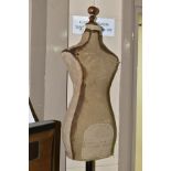 A VINTAGE CHILD SIZED SHOP MANNEQUIN, canvas covered body mounted onto a metal pole on cast metal