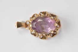 A 9CT GOLD AMETHYST PENDANT, of an oval form, claw set oval cut amethyst, within an openwork rope