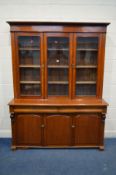 A VICTORIAN WALNUT BOOKCASE, triple glazed doors enclosing three fixed shelves, above two long