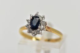 AN 18CT GOLD SAPPHIRE AND DIAMOND CLUSTER RING, centring on an oval cut blue sapphire (possibly