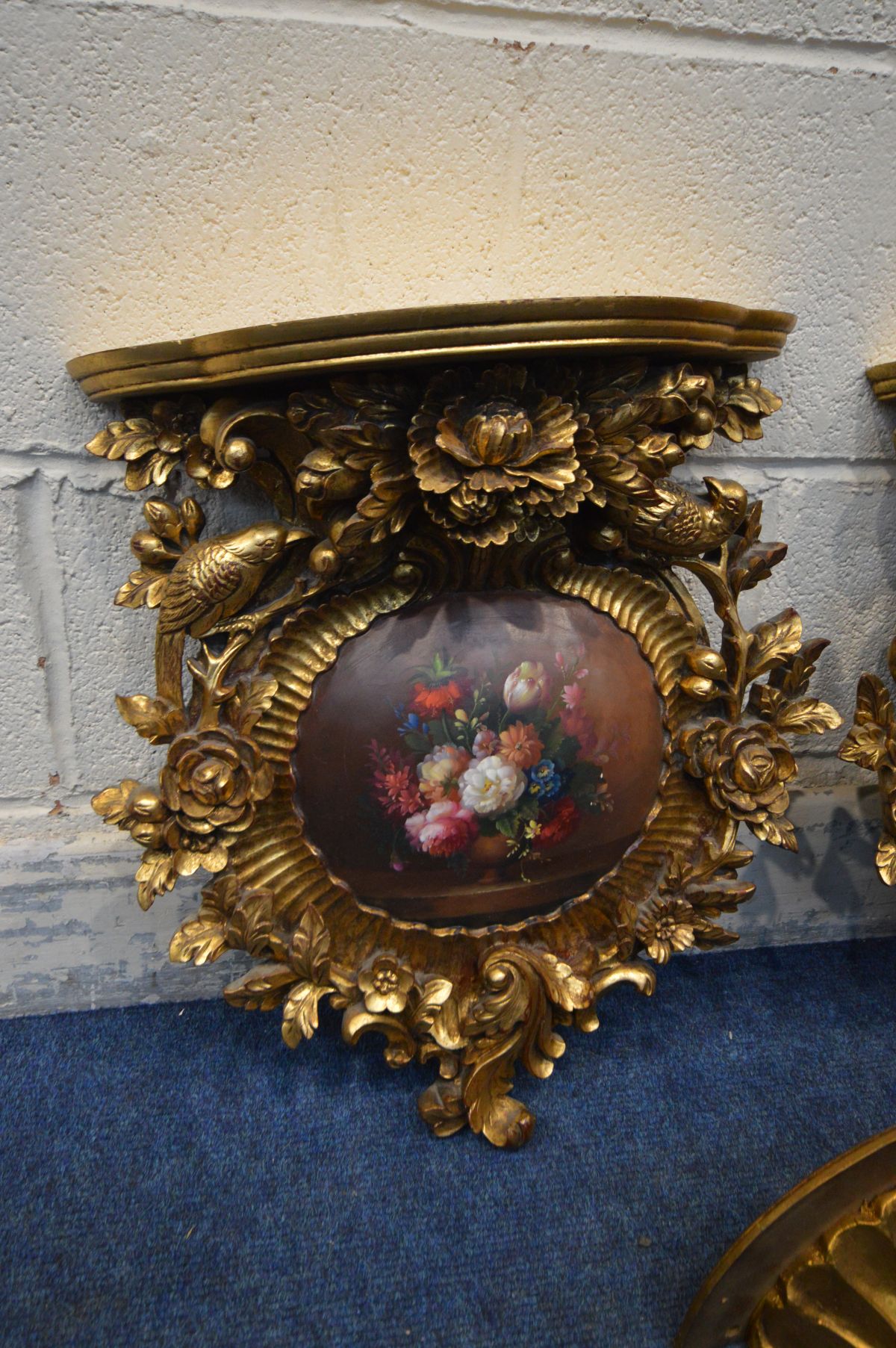 A PAIR OF LATE 20TH CENTURY GILTWOOD WALL SHELVES, florally carved surrounding a convex painting - Image 2 of 3