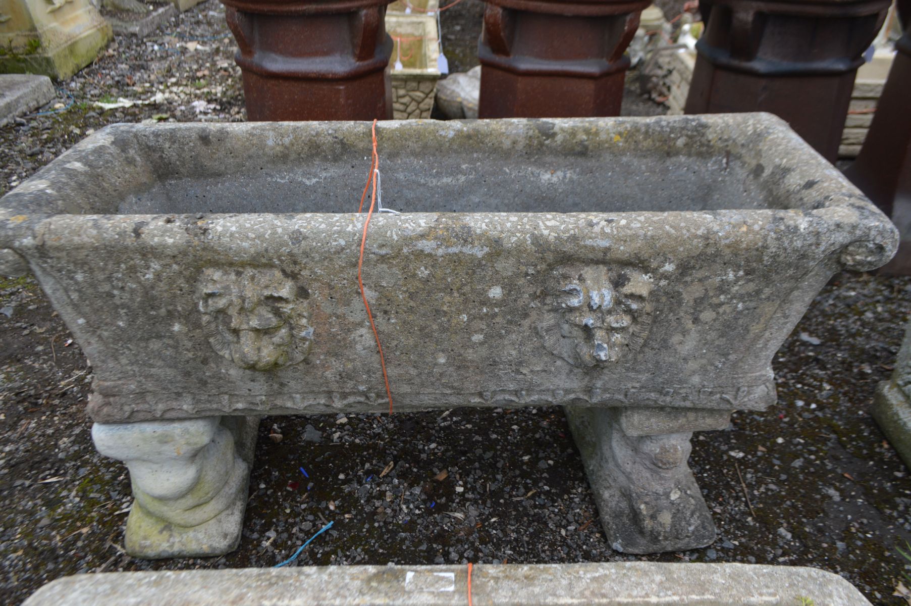 A COMPOSITE RECTANGULAR PLANTER with scrolled ends, on matched twin supports, width 98cm x depth