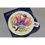 A BOXED MOORCROFT POTTERY PIN DISH, decorated with pink magnolia on a cream ground, painted and