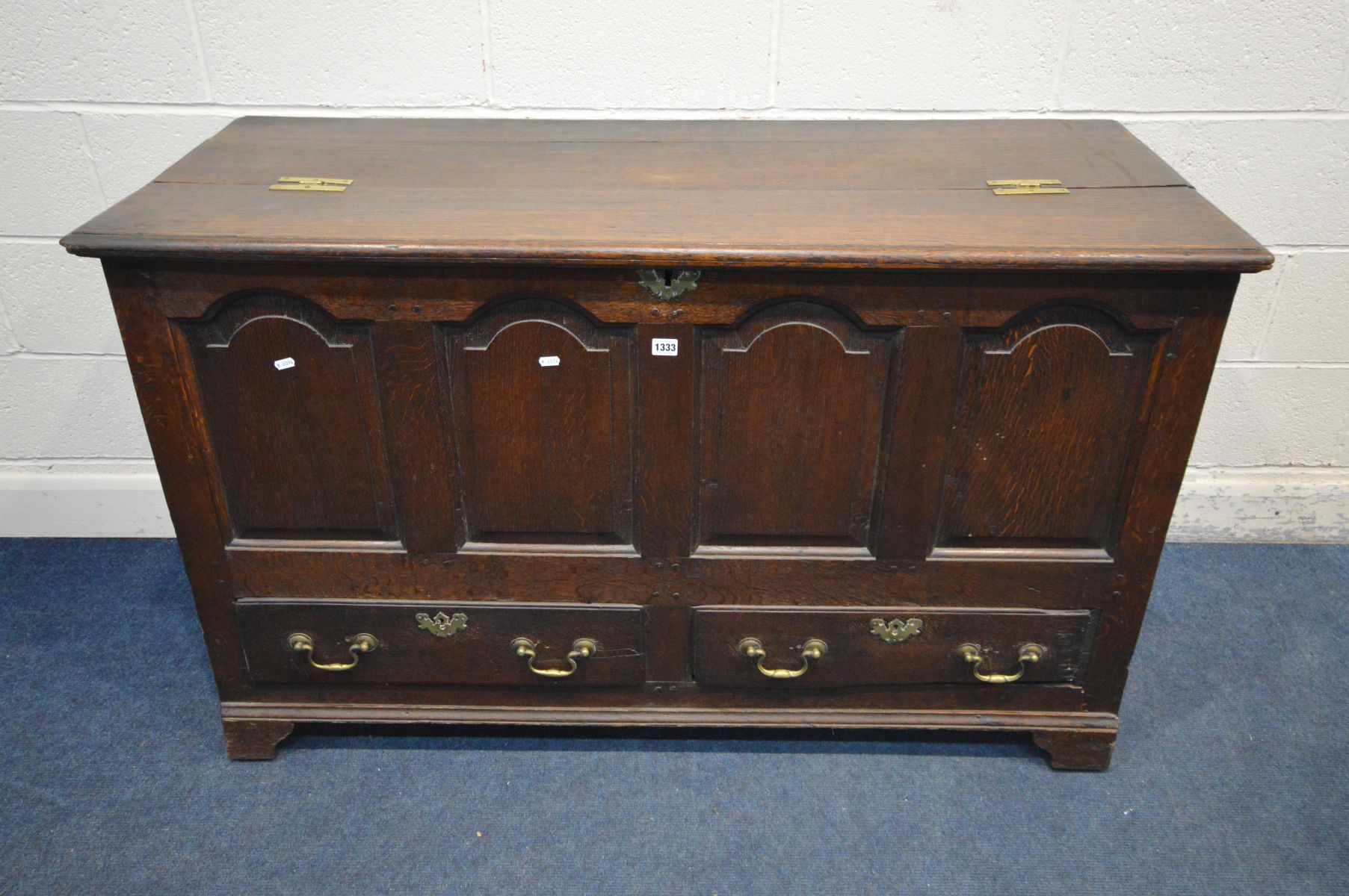 A GEORGIAN OAK MULE CHEST, four fielded panels above two drawers with brass escutcheons and drop