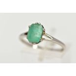 A WHITE METAL EMERALD RING, centering on a claw set emerald, cut emerald approximate dimensions 8.
