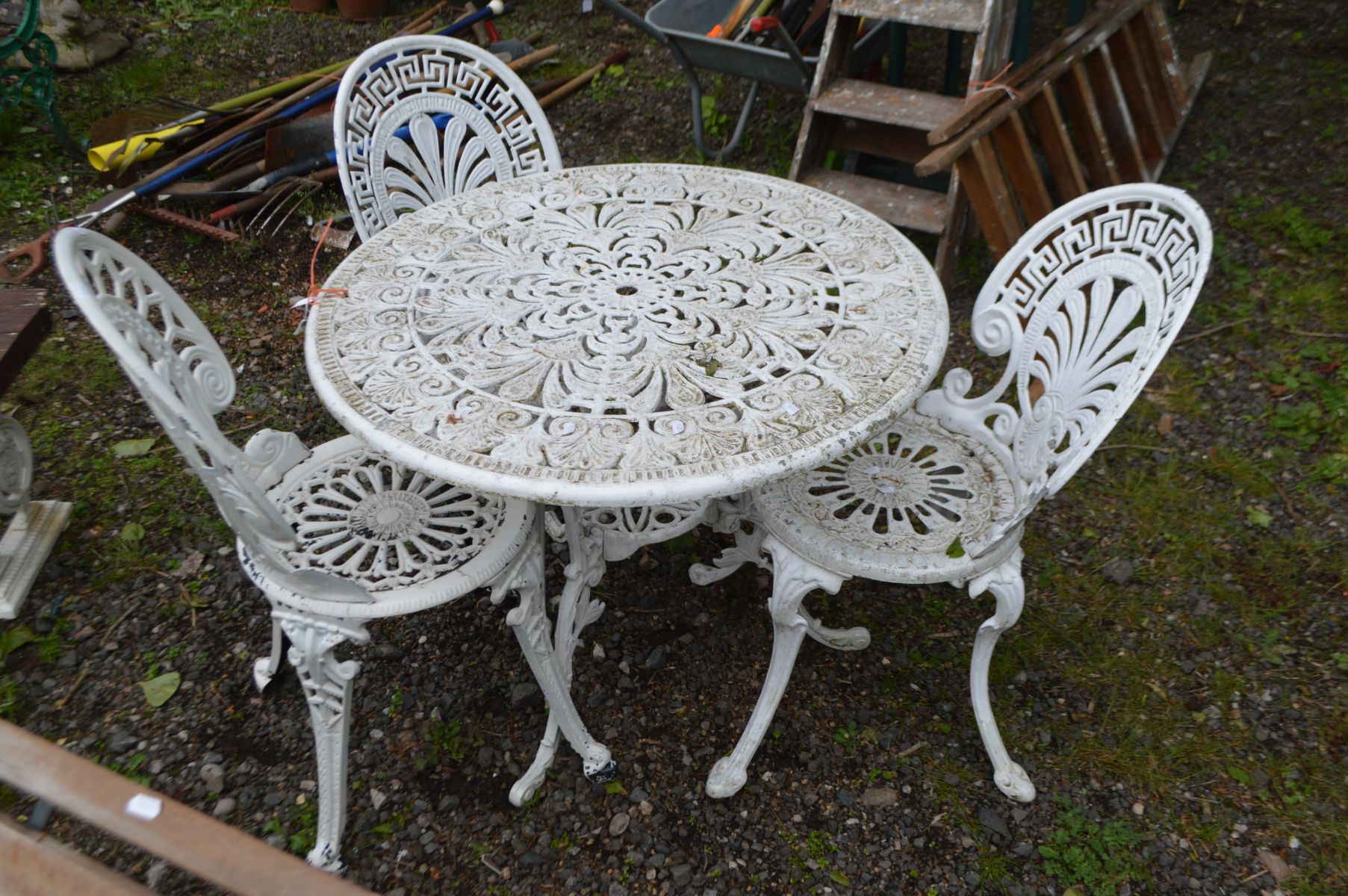 AN ALUMIUM WHITE PAINTED CIRCULAR GARDEN TABLE, diameter 82cm x height 65cm and three chairs (4)