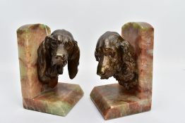 A PAIR OF EARLY 20TH CENTURY FRENCH ALABASTER BOOKENDS mounted with a bronzed springer spaniel on