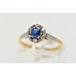 A YELLOW METAL CLUSTER RING, designed with a central, circular cut blue sapphire within a surround